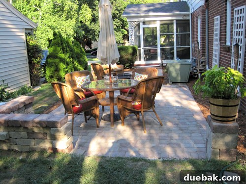 Build Your Backyard Paver Oasis 3 Beautifully finished DIY paver patio with seating wall, fire pit, and outdoor furniture