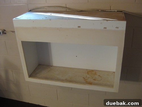 Dress Up Your Glass Doors with Gift Wrap 6 Before image of the dingy built-in basement cabinet