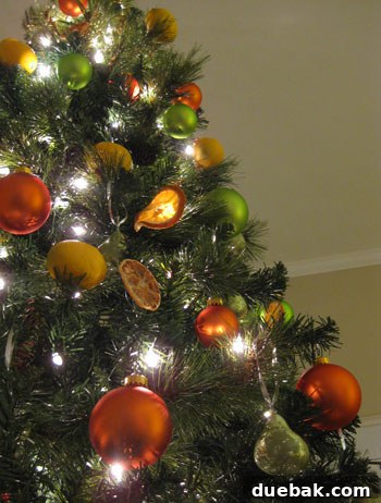 Crafting Radiant Dried Orange Ornaments 12 Green faux pears hanging on a Christmas tree with silver ribbons, complementing the citrus theme and adding a touch of unexpected charm.