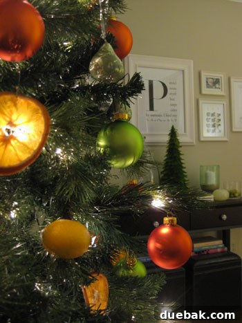 Crafting Radiant Dried Orange Ornaments 13 A full view of the brightly decorated Christmas tree, showcasing the dominant citrus theme with orange, green, and yellow ornaments and lights.