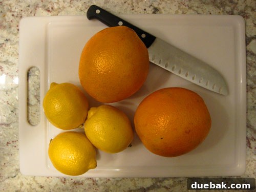Crafting Radiant Dried Orange Ornaments 4 Orange and lemon slices laid out on a baking sheet, ready for drying, showcasing the first step of the DIY ornament process.