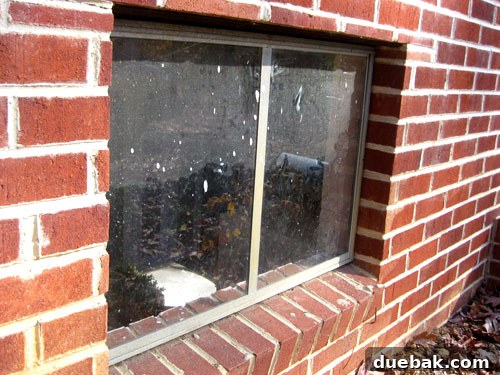 Dirty basement window with paint splatters