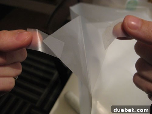 Window film with tape on opposite sides of a corner to aid separation