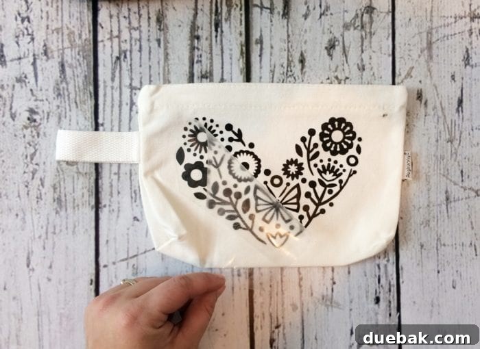 A floral folk design meticulously applied to a makeup bag using sleek black iron-on vinyl, demonstrating versatility.