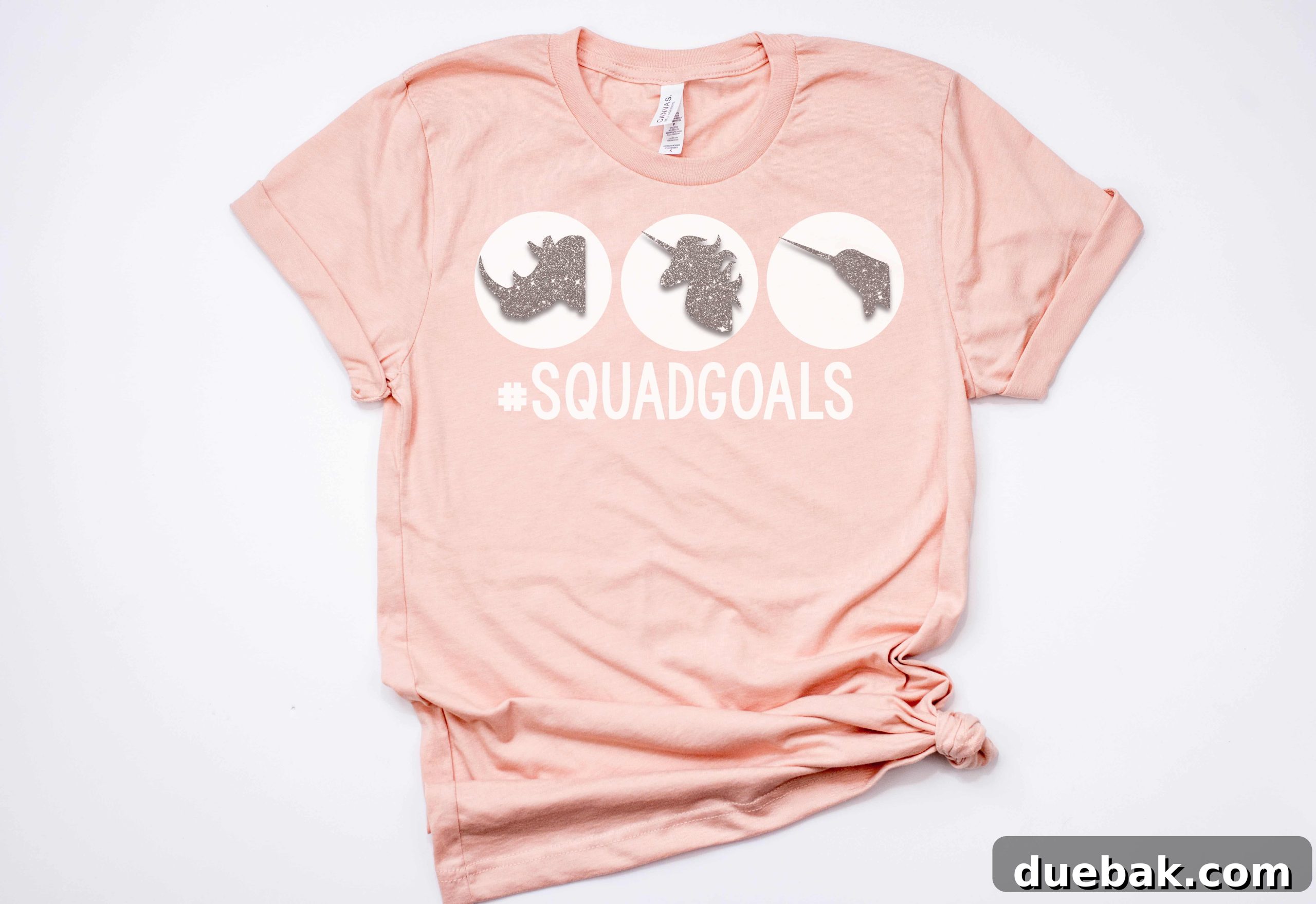 Close-up of a pink shirt displaying the 'Squad Goals' design with a rhino, unicorn, and narwhal, highlighted with glitter vinyl.