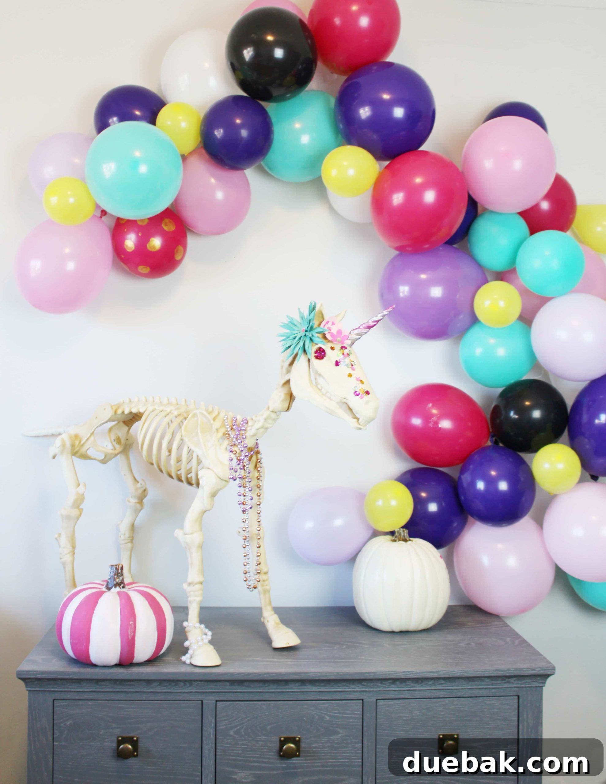 The Spectral Unicorn Soiree 2 Pink and purple unicorn skeleton Halloween decoration with balloon arch