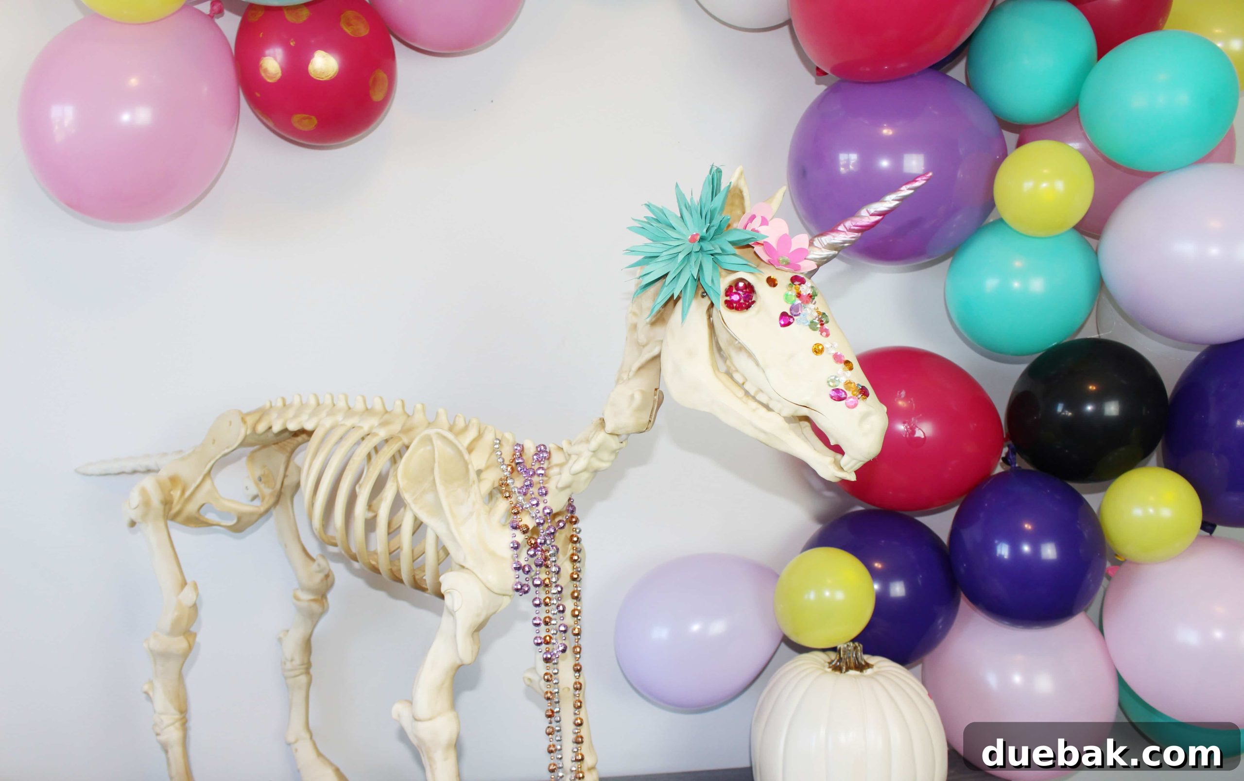 The Spectral Unicorn Soiree 4 Unicorn skeleton with decorative flowers and jewels, part of a bright Halloween display