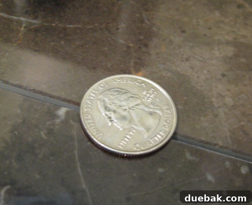 Checking tile levelness with a quarter trick on a marble floor