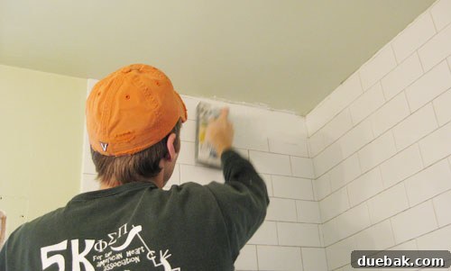 Applying grout to subway tiles with a grout float
