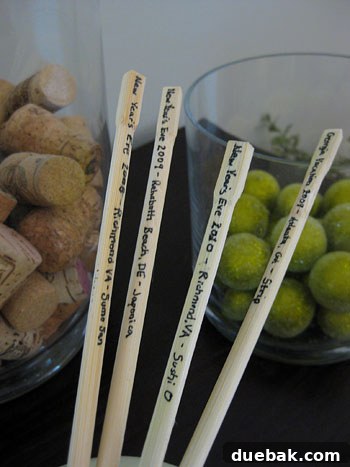 Close-up view of a collection of labeled chopsticks, clearly showing dates and diverse locations like Georgia, Delaware, and Richmond, VA, commemorating various New Year's Eve celebrations.