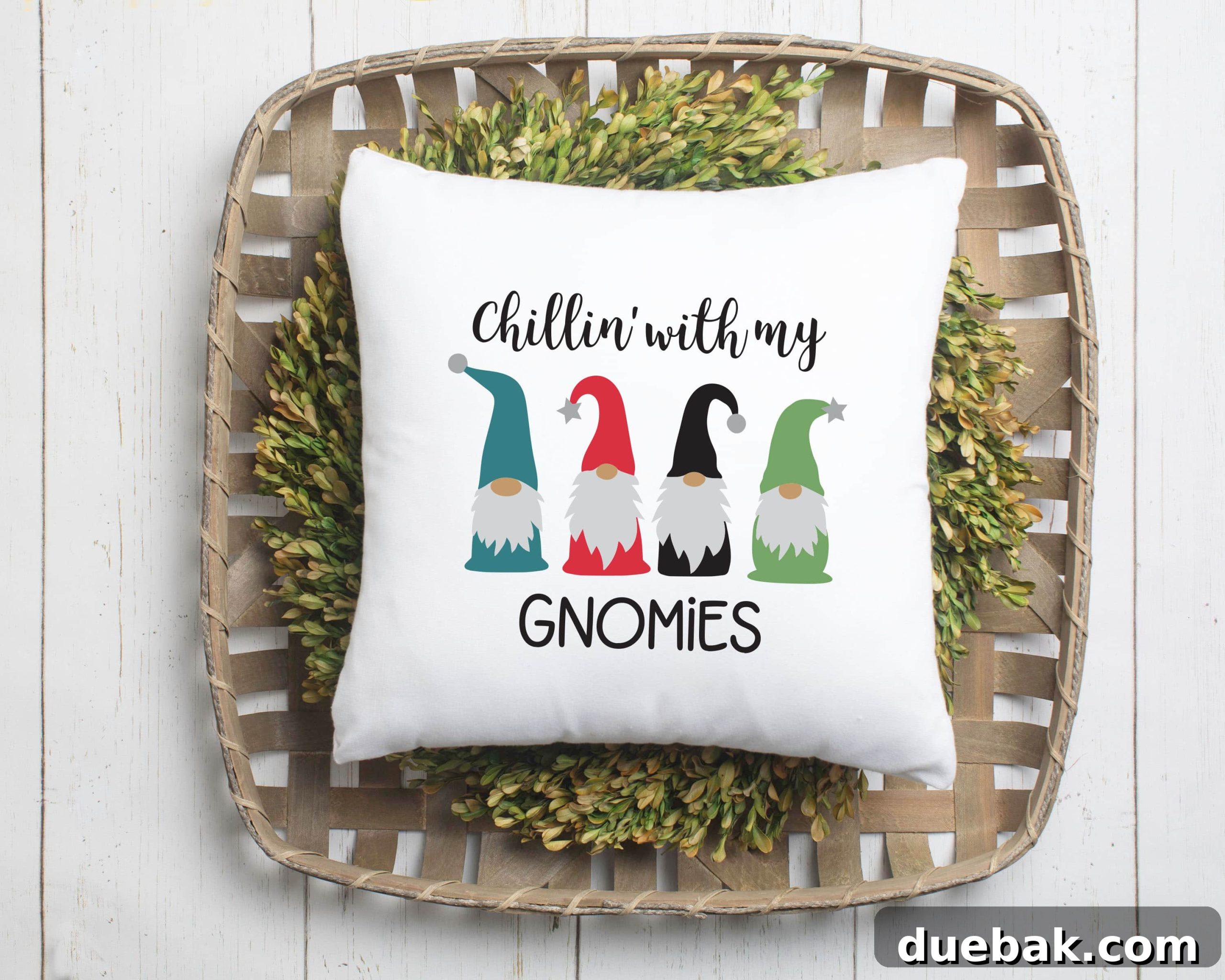 White canvas throw pillow on a box wood wreath sitting in a tobacco basket. The pillow has a design of 4 gnomes with the text Chillin With my Gnomies.