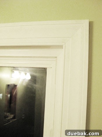 Elevate Your Bathroom Renovation with Flawless Baseboard and Trim Installation 12 Smoothing applied caulk into the trim seam with a finger for a seamless finish.