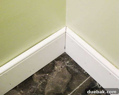 Elevate Your Bathroom Renovation with Flawless Baseboard and Trim Installation 16 Baseboard corner joint demonstrating a perfect bevel cut intersection.