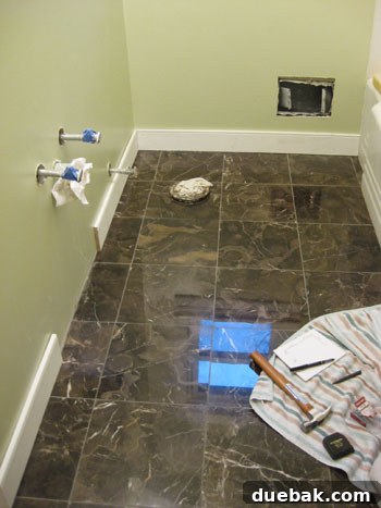 Elevate Your Bathroom Renovation with Flawless Baseboard and Trim Installation 17 Work zone for baseboard installation, showing a protective towel under the hammer area.