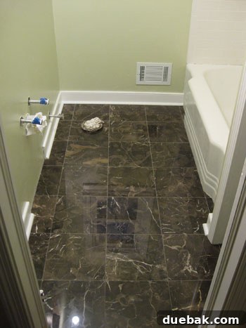 Elevate Your Bathroom Renovation with Flawless Baseboard and Trim Installation 18 Finished bathroom floor with newly installed baseboards and quarter-round molding.