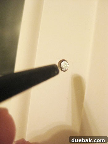 Elevate Your Bathroom Renovation with Flawless Baseboard and Trim Installation 9 A recessed nail head in the trim, prepared for caulking and painting.
