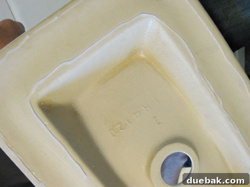 Applying silicone caulk to secure the vessel sink