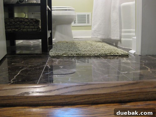 A newly installed dark walnut wooden threshold for a bathroom door