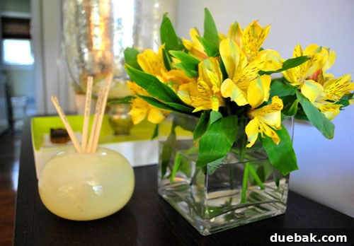 A beautiful vase filled with fresh, vibrant flowers and lush green leafy plants adorning a cozy living room, bringing life and natural texture to the space.