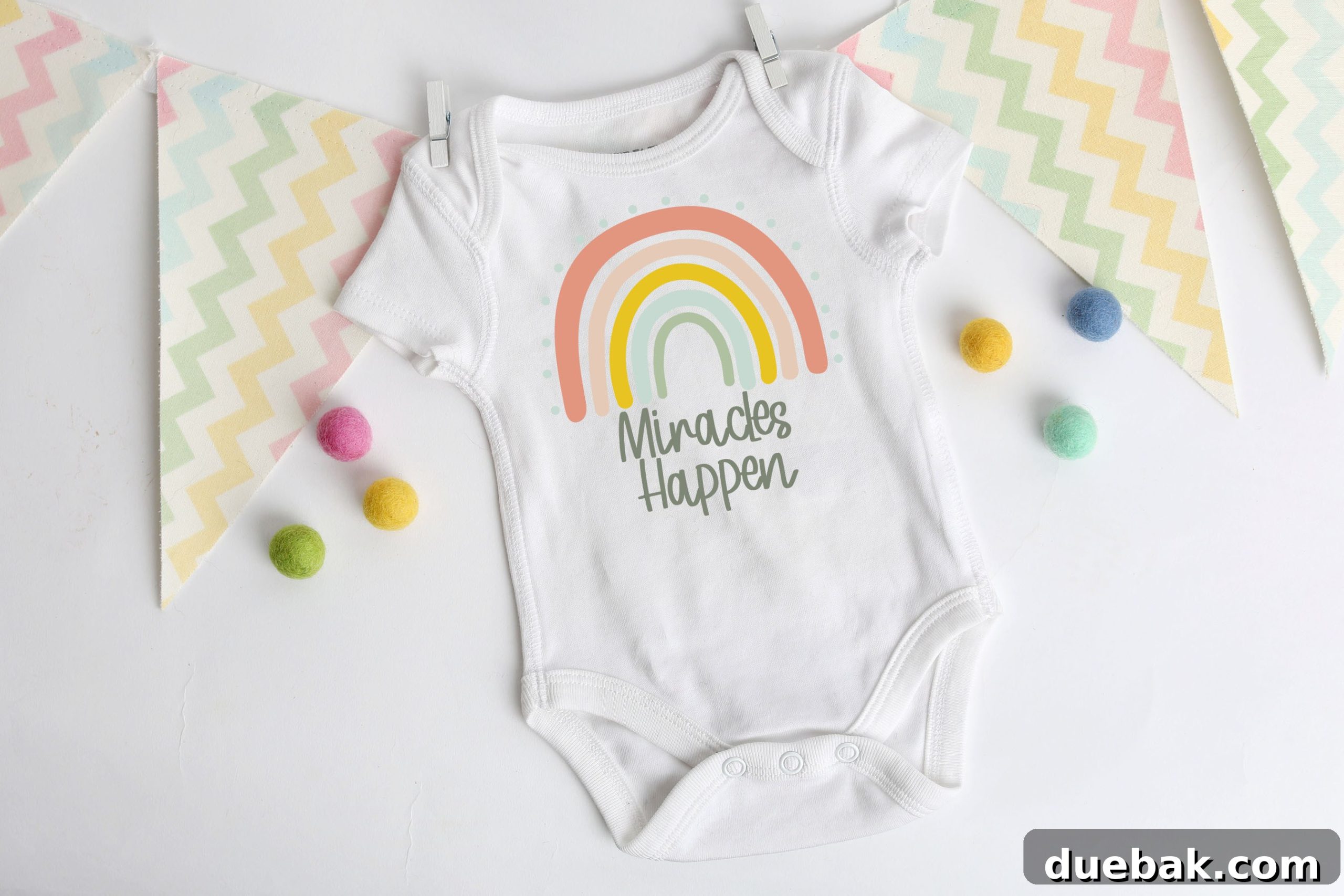 A rainbow baby onesie featuring the 'Miracles Happen' SVG design.