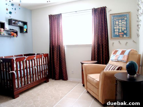 Close-up of nursery crib with Dwell bedding and paper star mobile.