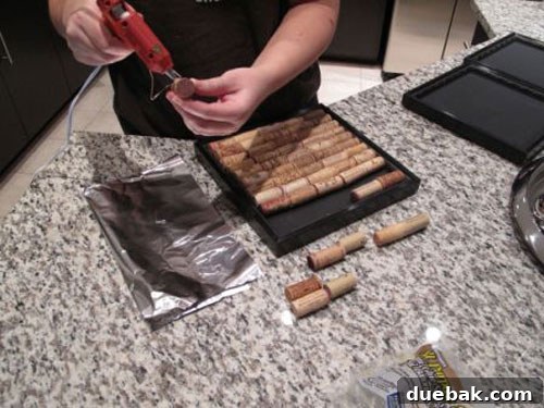 Wine Cork Memo Masterpiece 4 Emily carefully gluing individual wine corks into the painted frame using a hot glue gun.