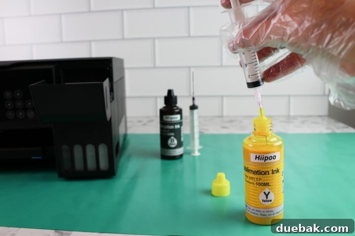 Unlock Sublimation Printing with Your EcoTank 12 Syringe being used to fill an Epson EcoTank printer with sublimation ink.
