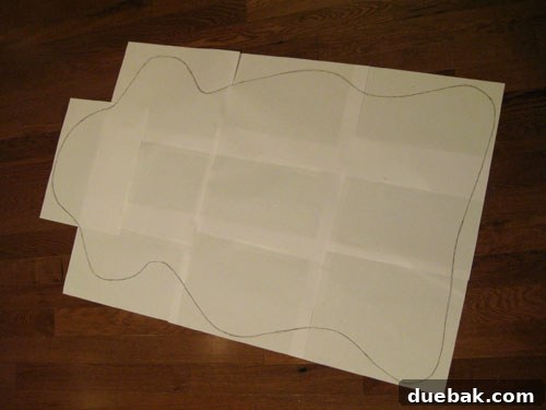 Pieces of paper taped together to form a large template, with a sheepskin shape sketched on it.