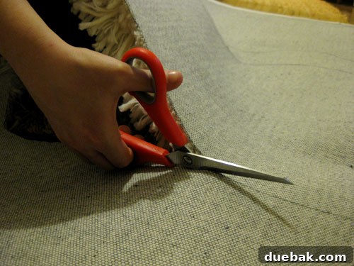 The process of cutting out the faux sheepskin shapes from the back of the rug.