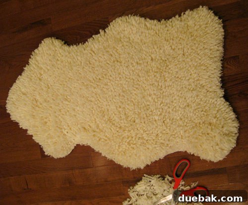 Two newly cut faux sheepskin rugs laid out, showcasing their soft, shaggy texture.