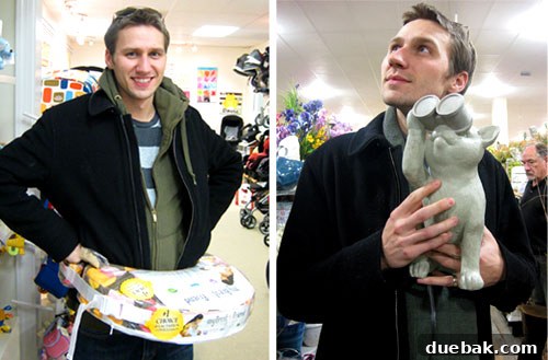 John posing with humorous baby items and decor