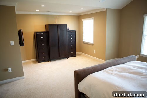 Before: Close-up of the bed area in the original bedroom, highlighting the bland and uninviting atmosphere.
