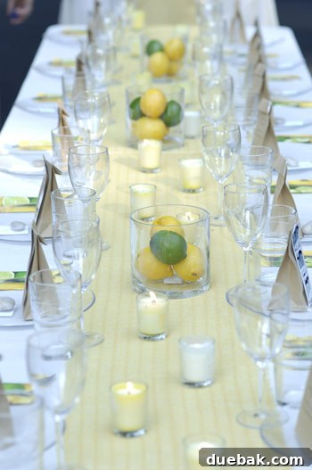 A clear glass vase filled with lemons and limes, creating a fresh and vibrant natural centerpiece.