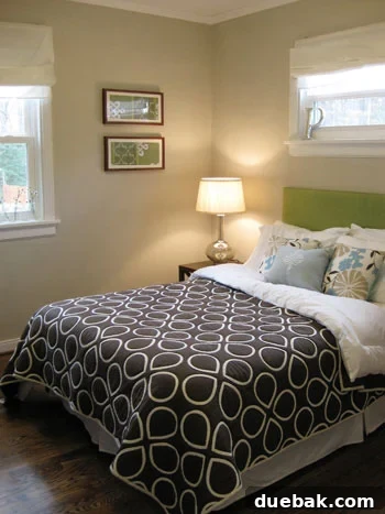 A stylish upholstered headboard in a vibrant green fabric, serving as a bold statement piece in a spring-decorated bedroom.