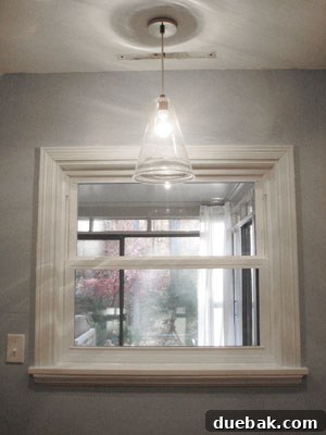 West Elm seeded glass pendant light hanging over a kitchen sink, part of a kitchen lighting renovation.
