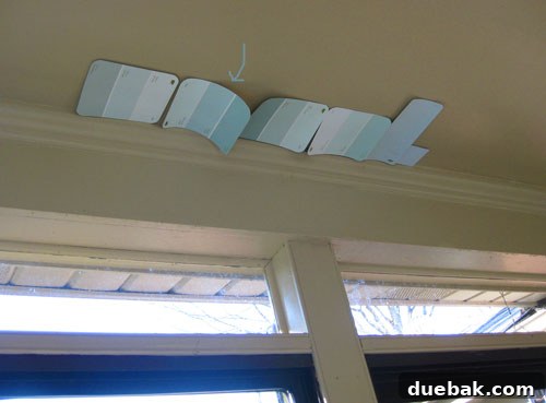 Seamless Corner Curtain Rod Installation 3 Paint swatches, including Behr Tide Pools, taped to sunroom ceiling for color selection