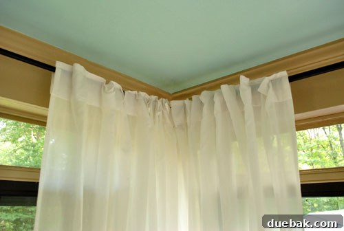 Seamless Corner Curtain Rod Installation 9 Two curtain panels elegantly meeting at a seamless corner in the sunroom
