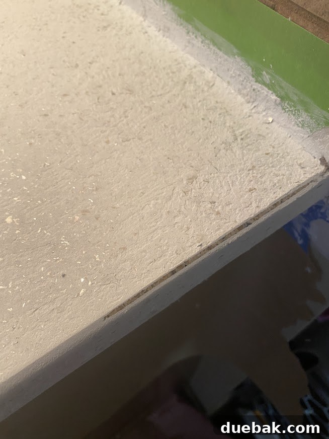 Revamp Your Granite Countertops with Paint 24 Close-up of a DIY resurfaced countertop edge being sanded.