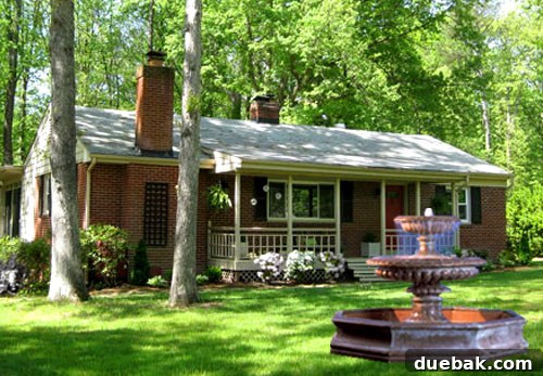 Elevated Curb Appeal 2 Elegant multi-tiered fountain gracing a beautifully landscaped front yard, enhancing curb appeal.