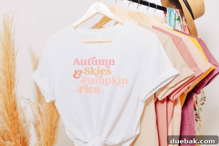 White t-shirt proudly displaying a fall-themed quote, hanging amidst a collection of other cozy seasonal apparel, perfect for autumn fashion.
