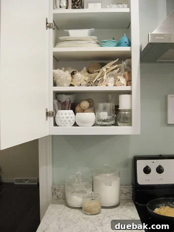 Three glass canisters filled with flour, sugar, and rice, placed on a kitchen counter next to a stove.