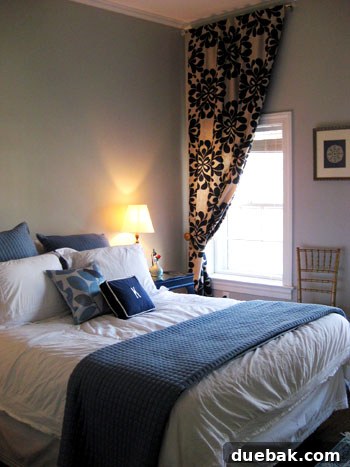 Step Inside This Exquisite City Residence 13 Master bedroom with tall ceilings and high-hung drapes, awaiting a DIY upholstered headboard.