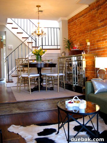 Step Inside This Exquisite City Residence 4 Dining room in Capitol Hill home with round table, mirrored buffet, and airy iron banister.