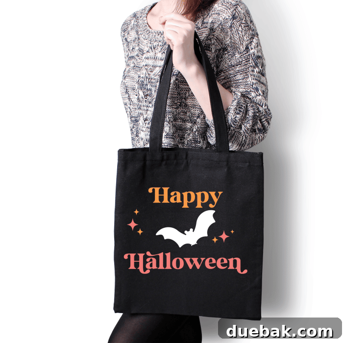 black tote bag with design of bat and happy halloween and midcentury style stars.