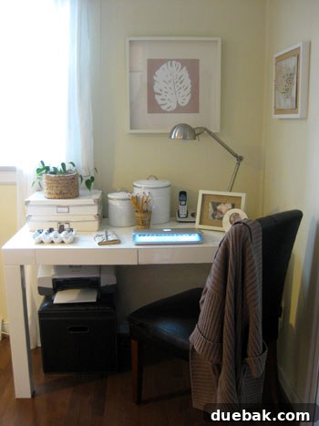Home office desk styled with natural accents and varied textures, including a plant, woven cup, and burlap frame.