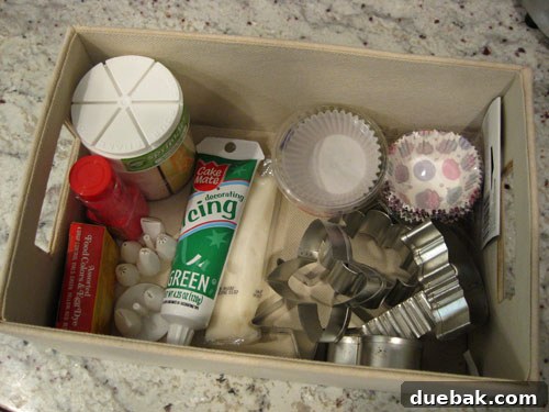 Box storing baking accessories like sprinkles and cookie cutters