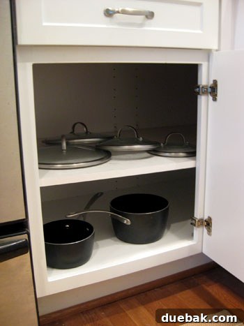 Before: Disorganized pots and lids in a kitchen base cabinet
