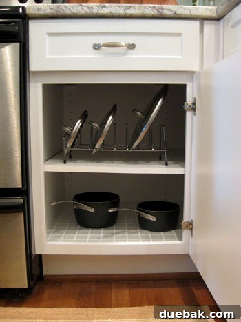 After: Organized pots and lids in cabinet with lid rack and protective mat