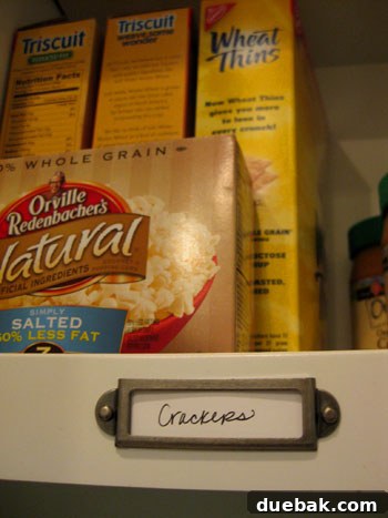 Close-up of metal label holder attached to a cabinet shelf