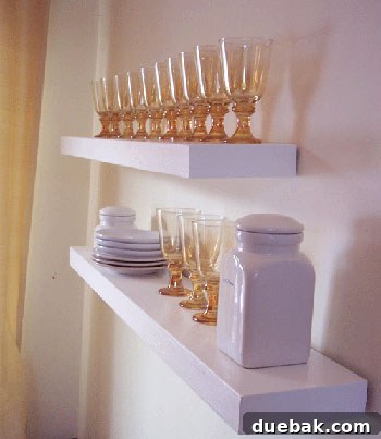 Beautiful do-it-yourself floating shelves, expertly crafted by Ana White, elegantly styled with glassware and decorative plates